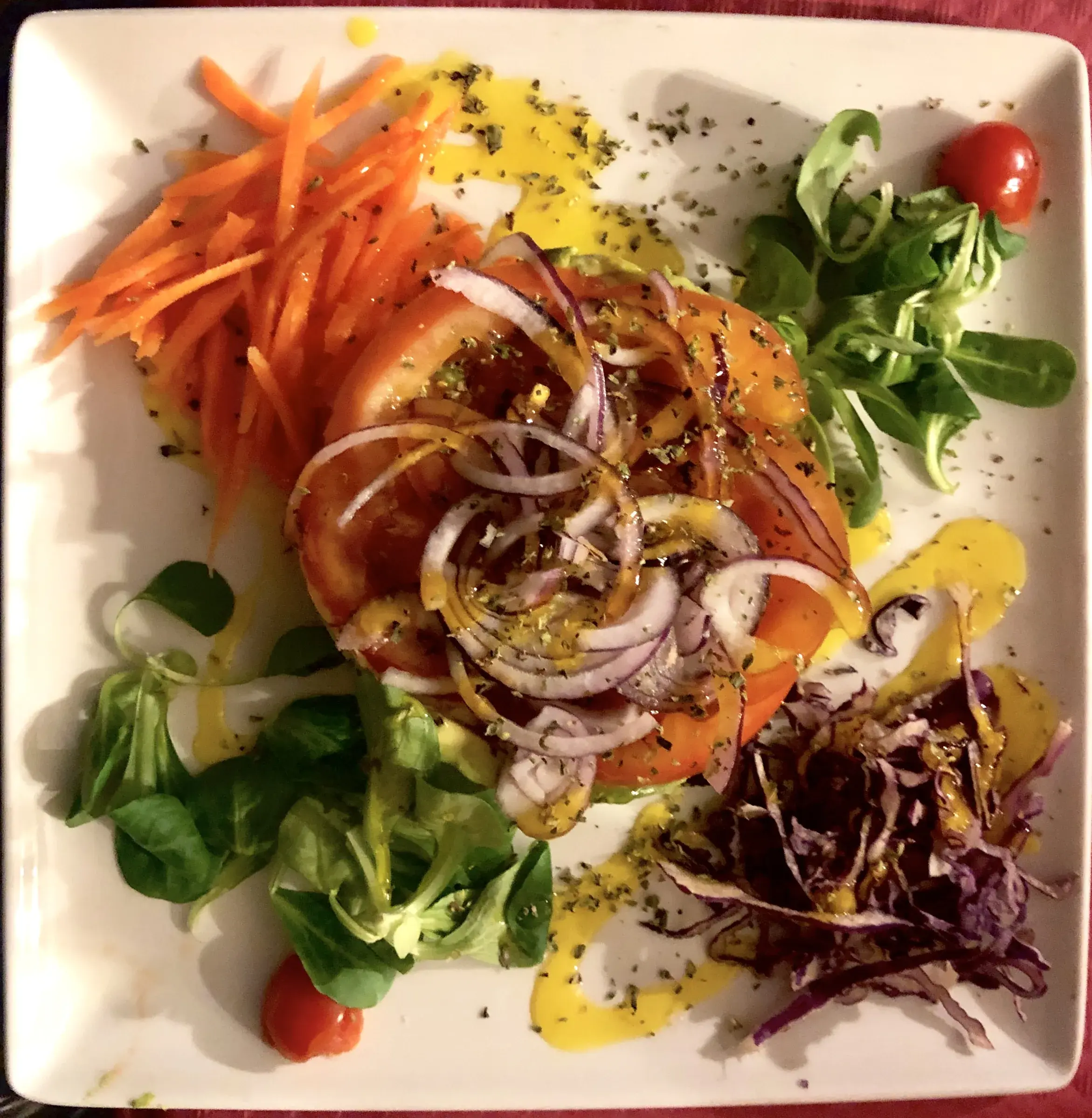 A simple Andalusian tomato salad — sliced tomato, red onion and olive oil — made in a Frigiliana kitchen.