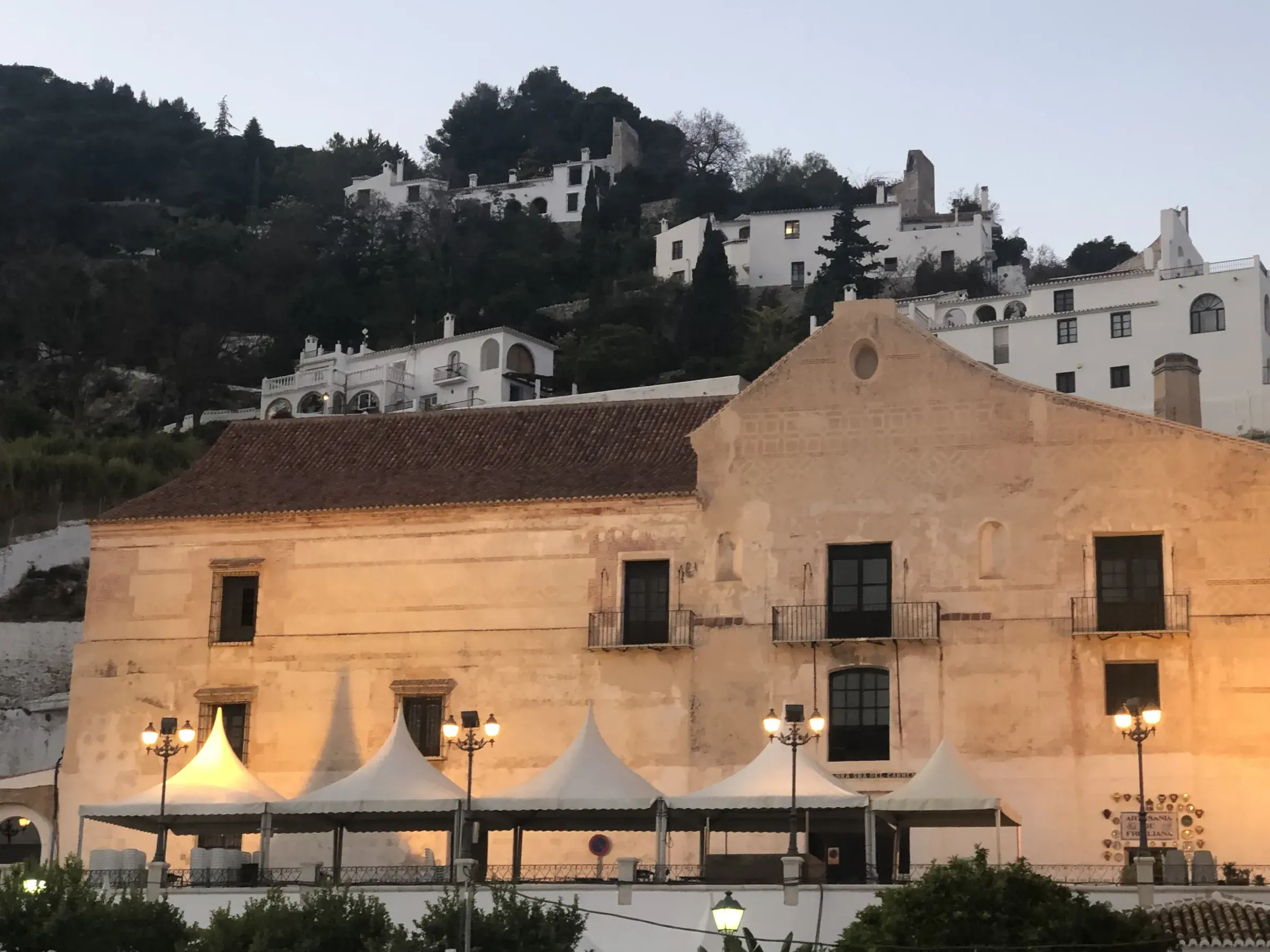 A Frigiliana plaza at dusk, lit windows and tapas-time atmosphere.