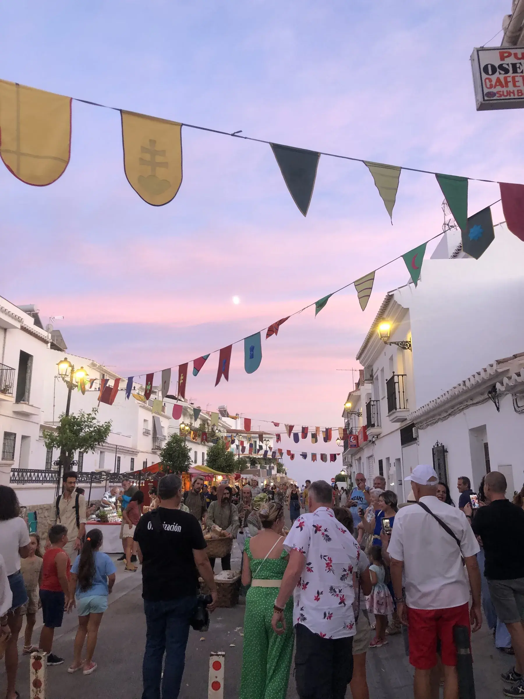 Bunting and crowds along Calle Real during the Festival of Three Cultures in Frigiliana.